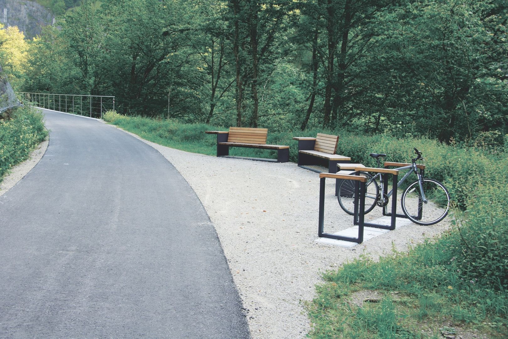 Moderne Holzbänke und Fahrradständern aus Stahl an einer Waldstraße